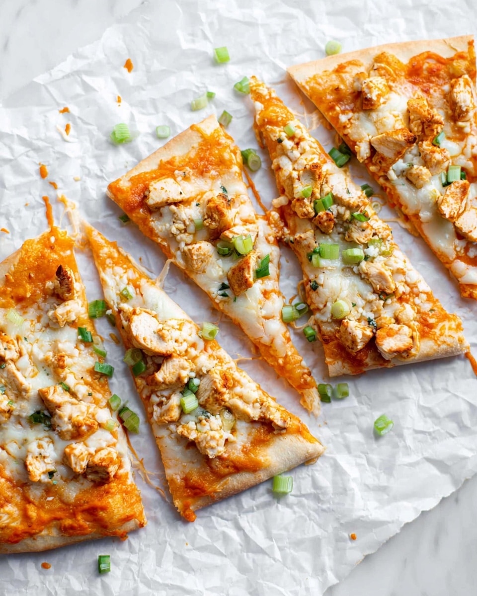 Four slices of pizza lie flat on a white marbled textured surface covered with crumpled white parchment paper. Each slice has a golden crust base topped with an even layer of orange sauce. On top of the sauce are small chunks of white cooked chicken scattered across the surface. Melted white cheese covers the chicken and sauce, with some melted cheese strands visible. Small, bright green chopped scallions are sprinkled evenly over the pizza slices, adding a fresh pop of color. The pizza has a slightly thick crust, lightly browned on the edges. The scene is brightly lit, showing the textures clearly. photo taken with an iphone --ar 4:5 --v 7