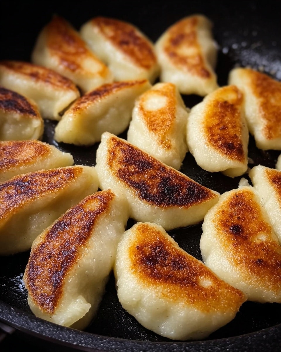 The image shows a close-up of many small dumplings cooking closely together in a black pan. Each dumpling has a soft off-white dough shell with a thick texture, and the bottom side of every piece is golden brown to dark brown with a slightly crisp look. The dumplings are shaped like small ovals and arranged side by side across the pan's surface. The black pan contrasts with the light color of the dough and the varying shades of golden brown on the cooked sides. photo taken with an iphone --ar 4:5 --v 7