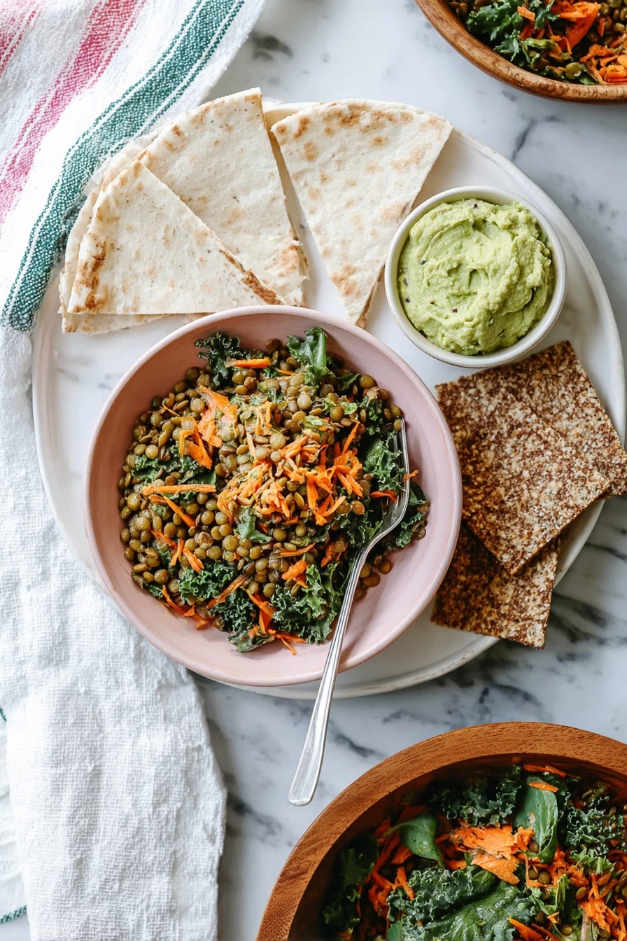 Moroccan Lentil Carrot Salad, vegan lentil and carrot salad, Moroccan spiced vegan salad, healthy vegan Moroccan salad, quick vegan lentil salad - A white bowl filled with a colorful lentil salad showing three clear layers: the bottom layer has small green lentils, the middle layer contains bright orange shredded carrots, and the top layer is dark green kale leaves mixed with small pieces of celery and bits of red onion, creating a textured and fresh look. The bowl is placed on a white plate that holds thin, white flatbread pieces folded into triangles, arranged in a fan shape behind the bowl. The scene is set on a white marbled surface with a fork tucked inside the bowl on the left side. Photo taken with an iphone --ar 2:3 --v 7