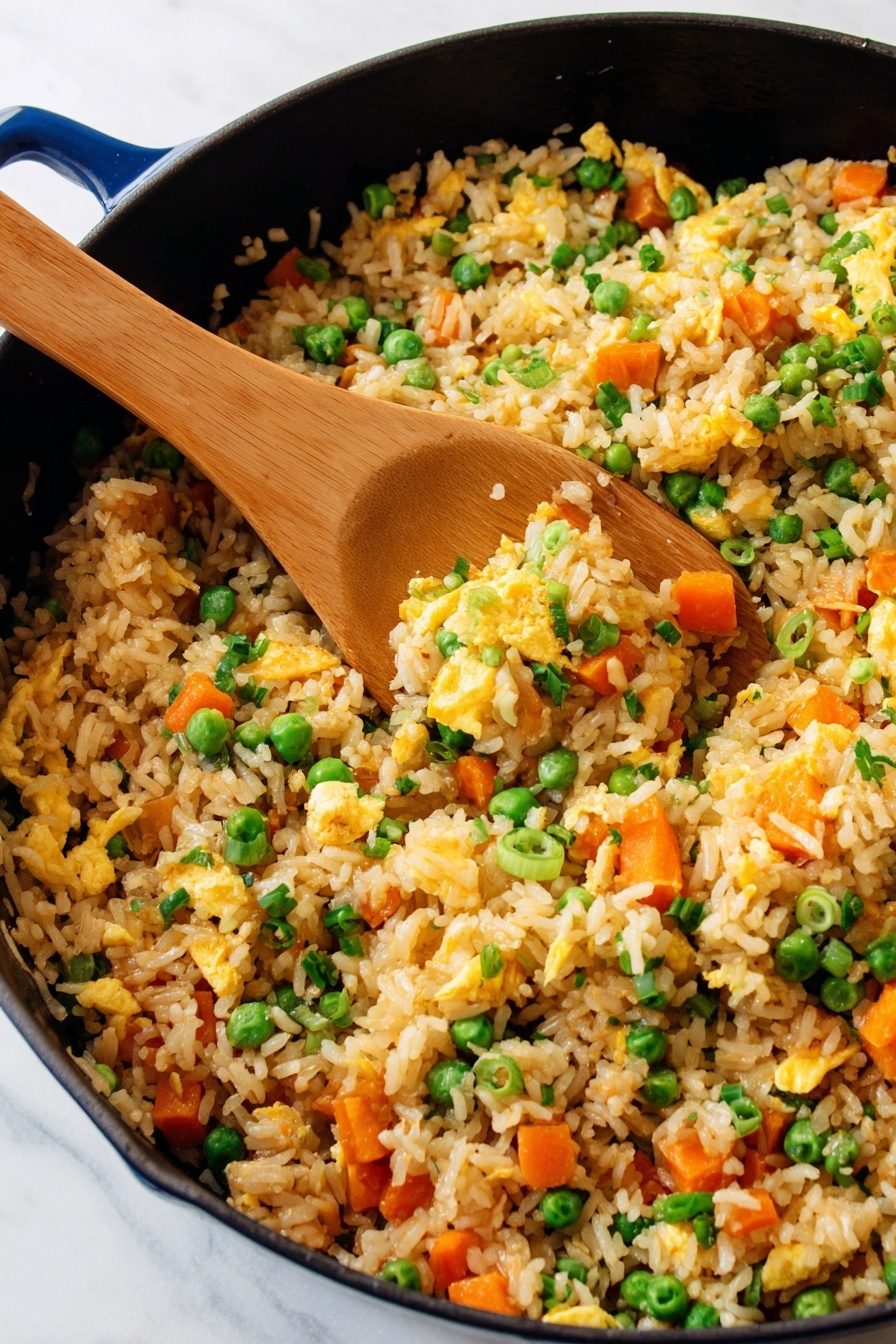 Air Fryer Fried Brown Rice, healthy fried rice, easy air fryer recipes, quick brown rice dinner, guilt-free fried rice - The image shows a beige bowl filled with fried rice, containing visible layers of light brown cooked rice mixed with bright orange carrot cubes, green peas, and chopped green onions scattered evenly throughout. Small pieces of scrambled egg add a soft yellow texture, blending naturally with the rice and vegetables. A white spoon rests inside the bowl, partially scooping some of the fried rice. To the top left, a white plate with a fork holds a small portion of the same fried rice. The background is a white marbled surface with a yellow glass of liquid partially visible in the top right corner. photo taken with an iphone --ar 2:3 --v 7