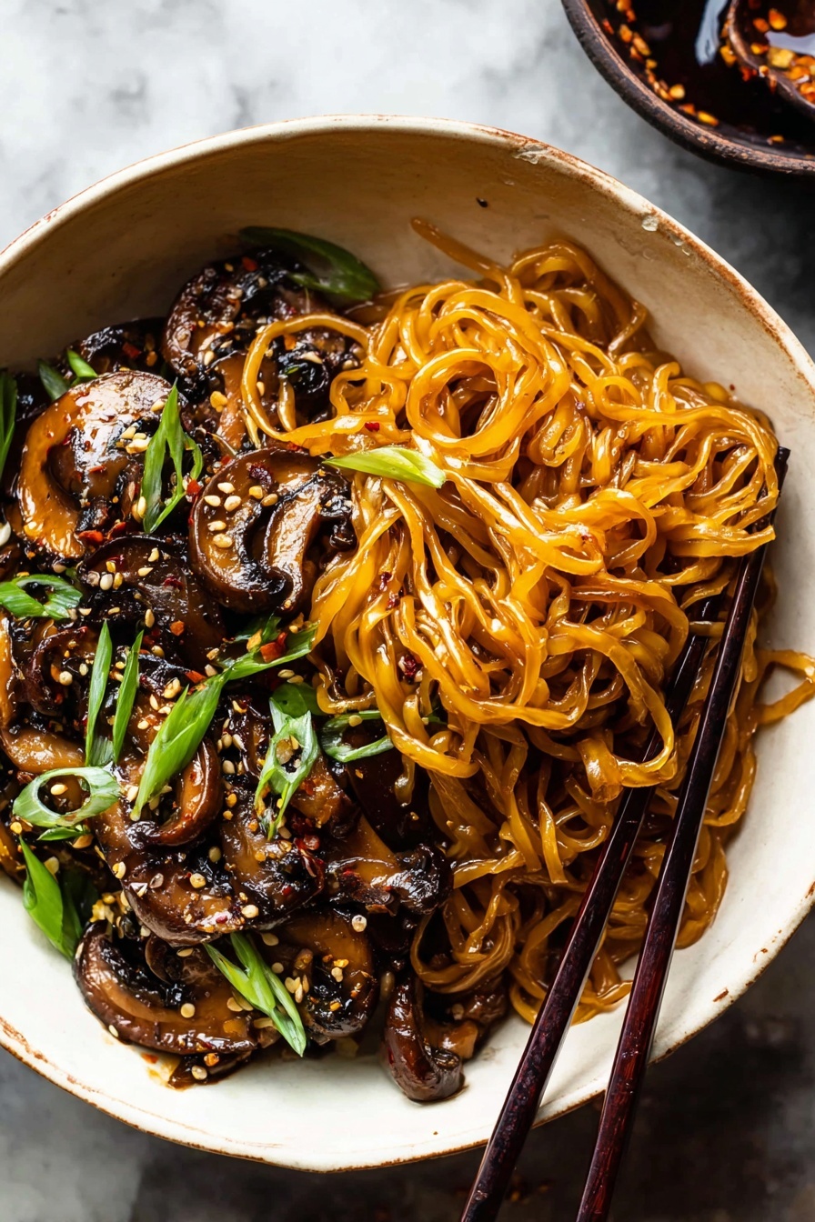 Saucy Ginger Sesame Noodles with Caramelized Mushrooms, quick Asian noodle recipes, easy weeknight dinner ideas, flavorful mushroom noodle stir-fry, 30-minute Asian noodles - A deep white bowl filled with a serving of glossy, amber-colored noodles arranged in loose swirls on one side. Next to the noodles are dark brown, sautéed mushroom slices with a shiny, slightly oily texture, sprinkled with sesame seeds and small bits of chili flakes. Bright green sliced scallions are scattered over both the noodles and mushrooms for a fresh contrast. A pair of dark wooden chopsticks rests on the edge of the bowl, holding some noodles. The bowl sits on a white marbled surface. photo taken with an iphone --ar 2:3 --v 7
