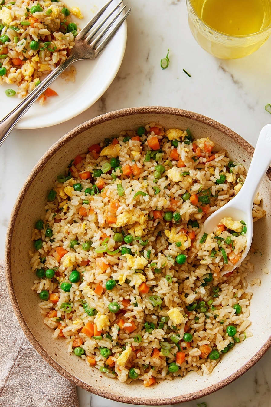 Air Fryer Fried Brown Rice, healthy fried rice, easy air fryer recipes, quick brown rice dinner, guilt-free fried rice - A white plate holds a serving of fried rice with visible layers of light brown rice mixed with bright orange carrot cubes, green peas, small pieces of scrambled egg in pale yellow, and chopped green onions scattered on top. To the right, a large beige bowl with a brown rim contains more fried rice with the same mix, some rice missing from the side. A white ceramic spoon with more fried rice rests near the bowl. Above the plate and bowl, a small white bowl holds extra chopped green onions. At the bottom center, a clear glass cup filled with yellow cooking oil sits on a white marbled textured surface. A fork with a wooden handle lays on the left side of the white plate. The photo taken with an iphone --ar 2:3 --v 7